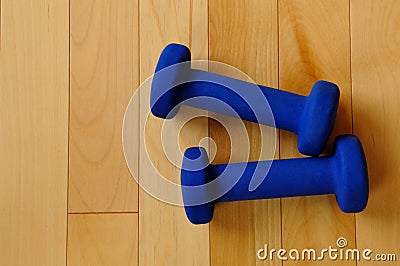 Blue Weights on Hardwood Floor of Fitness Center Stock Photo