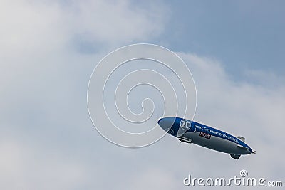 Blue and white airship in the sky with "Next Generation Mobility" advertisement on it Editorial Stock Photo