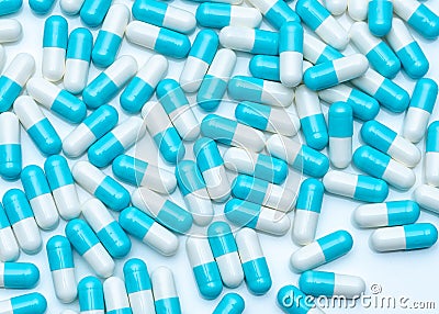 Blue-white capsule pills on white table. Full frame of capsule drug pills. Pharmacy product. Pharmaceutical production concept. Stock Photo