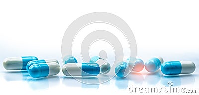 Blue and white capsules pill spread on white background with shadow and copy space. Global healthcare concept. Antibiotics drug Stock Photo