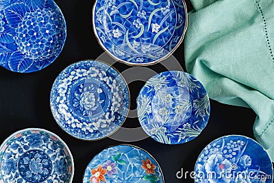 Blue and white decorative Japanese ceramic plates on black background - overhead photo Stock Photo
