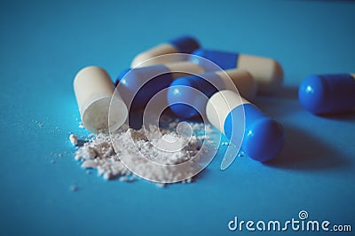 blue white pills in capsules with white powder medicine pharmacy pharmaceuticals health supplements Stock Photo