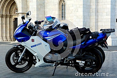 Blue and white sport and touring bikes in bright summer light in front of stone church facade Editorial Stock Photo