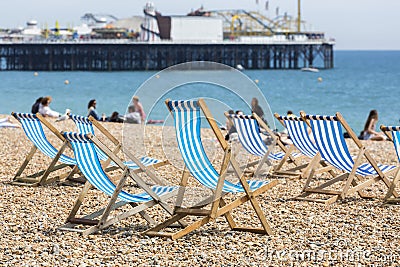 Blue and white striped deckchairs on Brighton beach Stock Photo