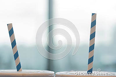 Blue and white striped organic paper straw in blue paper cup Stock Photo