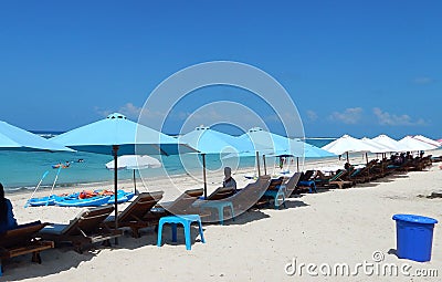 Blue and white umbrellas and chaise longue Stock Photo