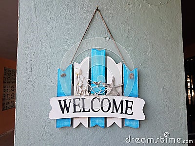 Blue and white welcome sign with shells on wall Stock Photo
