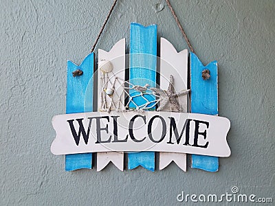 Blue and white welcome sign with shells on wall Stock Photo