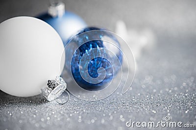 Blue and white xmas ornaments on glitter holiday background. Merry christmas card. Stock Photo