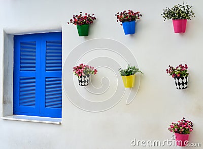 Blue window and colorful fake flower in the zinc vase Stock Photo