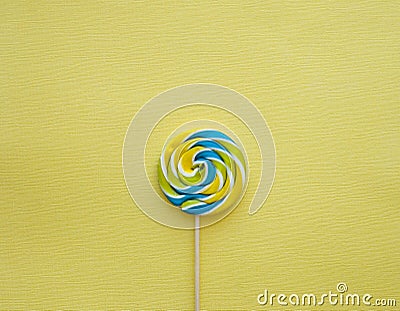 Blue yellow lollypop on yellow background Stock Photo