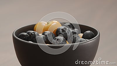 blueberries in black bowl with physalis closeup Stock Photo