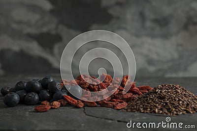 Blueberries, Goji, and Flax Seeds on a Stone Surface Stock Photo