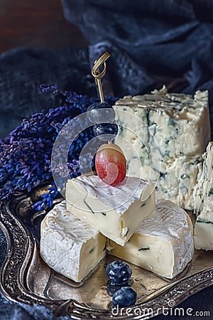 Blueberries and grapes with cheese Gorgonzola and Camembert with lavender. Close. Village. Stock Photo