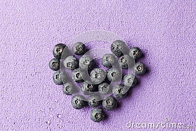 Blueberries heart on purple from above Stock Photo