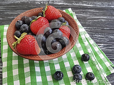 Blueberries, strawberries towel antioxidant on an old black wooden summer Stock Photo