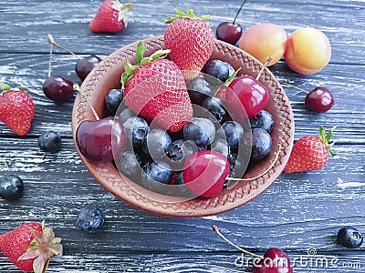 Blueberries, strawberries raw seasonal vitamin group rustic cherry sweet on an old black wooden Stock Photo