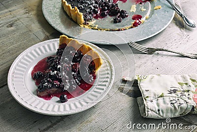 Blueberry and blackberry tart. Freshly baked dark berry pie, shown on a rustic table. Stock Photo