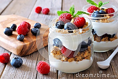 Blueberry, raspberry parfaits in mason jars, still life over wood Stock Photo