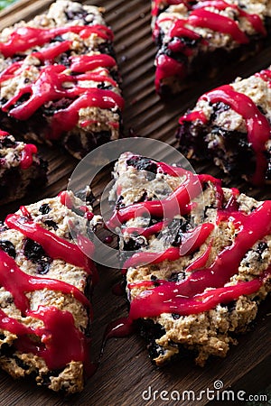 Blueberry scones with raspberry jam topping on oak cutboard close up Stock Photo