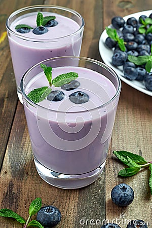 blueberry yogurt with fresh berries and mint leaves and a plate of blueberries Stock Photo