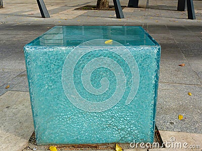 Blue and white glass seat on public street with shattered side Stock Photo