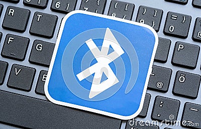 Bluetooth technology logo symbol card, sticker, label laying on a modern laptop computer keyboard, Bluetooth devices support Editorial Stock Photo