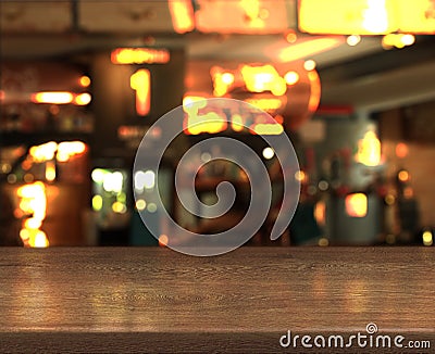 Blur bokeh background with empty wooden table top in night cafe Stock Photo