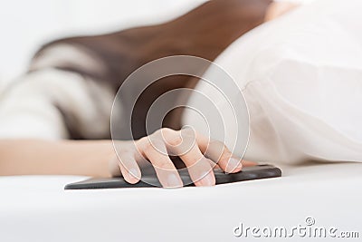 Blur Woman woke up by smartphone alarm clock and turning off snoozing phone alarm clock. Stock Photo