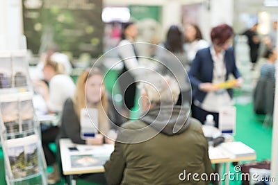 Blured image of client consulting aobout product with saleswoman at business fair. Stock Photo