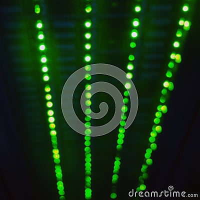 Blurred abstract background of green server lamps, bokeh light lights in a row Stock Photo