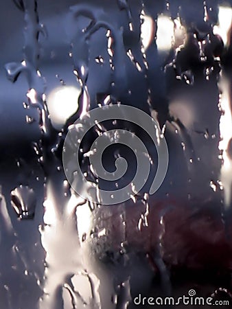 Blurred abstract moody defocused close-up background of bad weather raindrops splashing against a wet transparent glass window Stock Photo