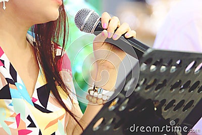 Blurred asia singer hands holding microphone on stage Stock Photo