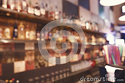 Blurred back bar. Bottles of spirits and liquor at the bar. Blurred desk in bar. Stock Photo
