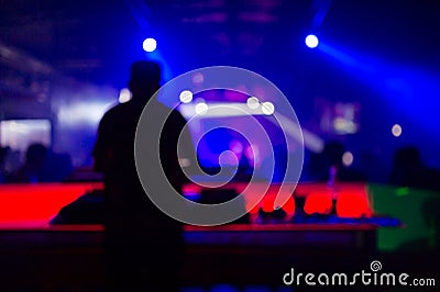 Blurred background : Club, disco DJ playing and mixing music for crowd of happy people. Nightlife, concert lights Stock Photo