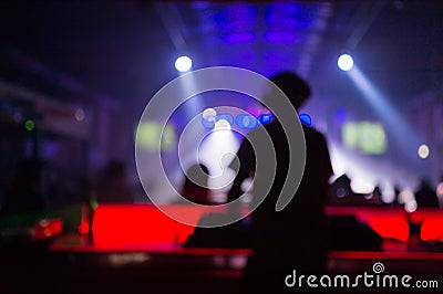 Blurred background : Club, disco DJ playing and mixing music for crowd of happy people. Nightlife, concert lights Stock Photo