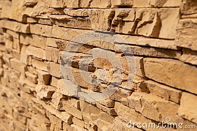 Blurred background of yellow slate stone surface. Blocks of artificial finishing stone for wall decoration. Rough stone background Stock Photo