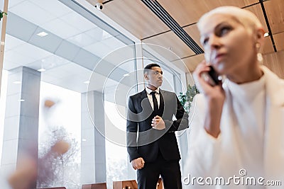 blurred businesswoman talking on smartphone near Stock Photo