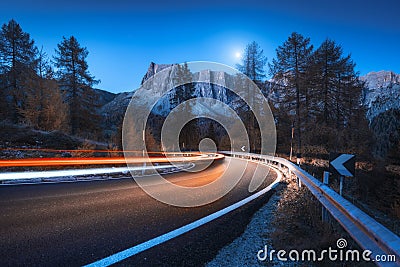 Blurred car headlights on winding road at night in autumn Stock Photo