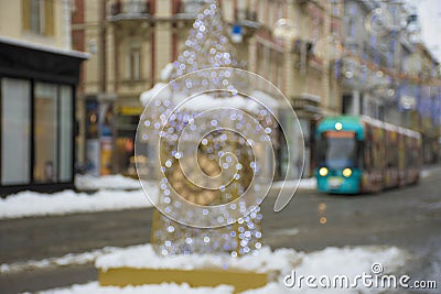 Blurred Christmas lights with famous Clock Tower on Herrengasse street in the city center of Graz, Steiermark, Austria, in snowy Stock Photo