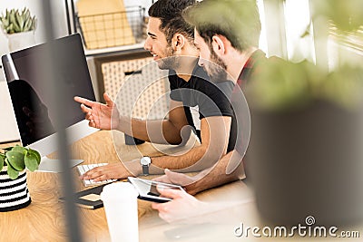 Blurred close-up of a plant with coworkers smiling and sitting i Stock Photo