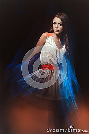 Blurred color art portrait of a girl on a dark background. Fashion woman with beautiful makeup and a light summer dress. Sensual Stock Photo