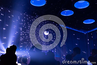 Blurred concept night scene in concert party with silhoette audience. Stock Photo