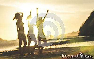 Blurred defocused silhouette of women travelers at sunset - Travel wanderlust concept with young girlfriends partying and dancing Stock Photo