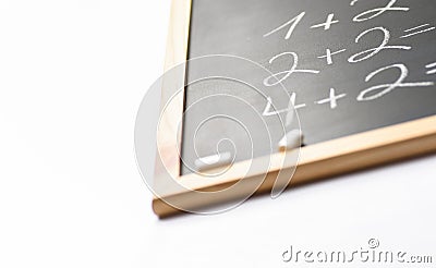 Blurred Fragment of Black Chalkboard with Hand Written Simple Mathematics Equations White Chalks. Back to School Concept Education Stock Photo