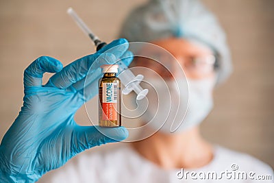 Blurred image: doctor holding syringe and coronavirus Covid-19 vaccine vial. Vaccination, pharmaceutical research concept Stock Photo