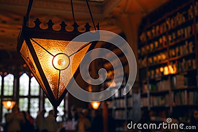 Blurred image, many old books on the bookshelf in the library, a large triangular lamp Stock Photo
