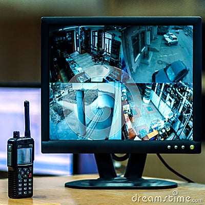 Blurred image on the monitor screen from four cameras by video surveillance. Workplace. CCTV. The policeman`s radio is nearby. Sq Stock Photo