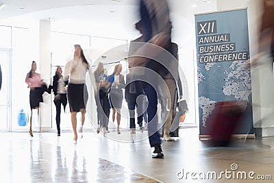 Blurred motion of business people walking in convention center Stock Photo