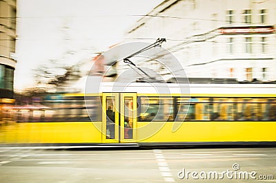 Blurred motion of defocused yellow tram on the streets of Berlin Stock Photo